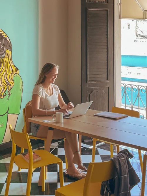 Lizzie working on her laptop in a bright Valencia café